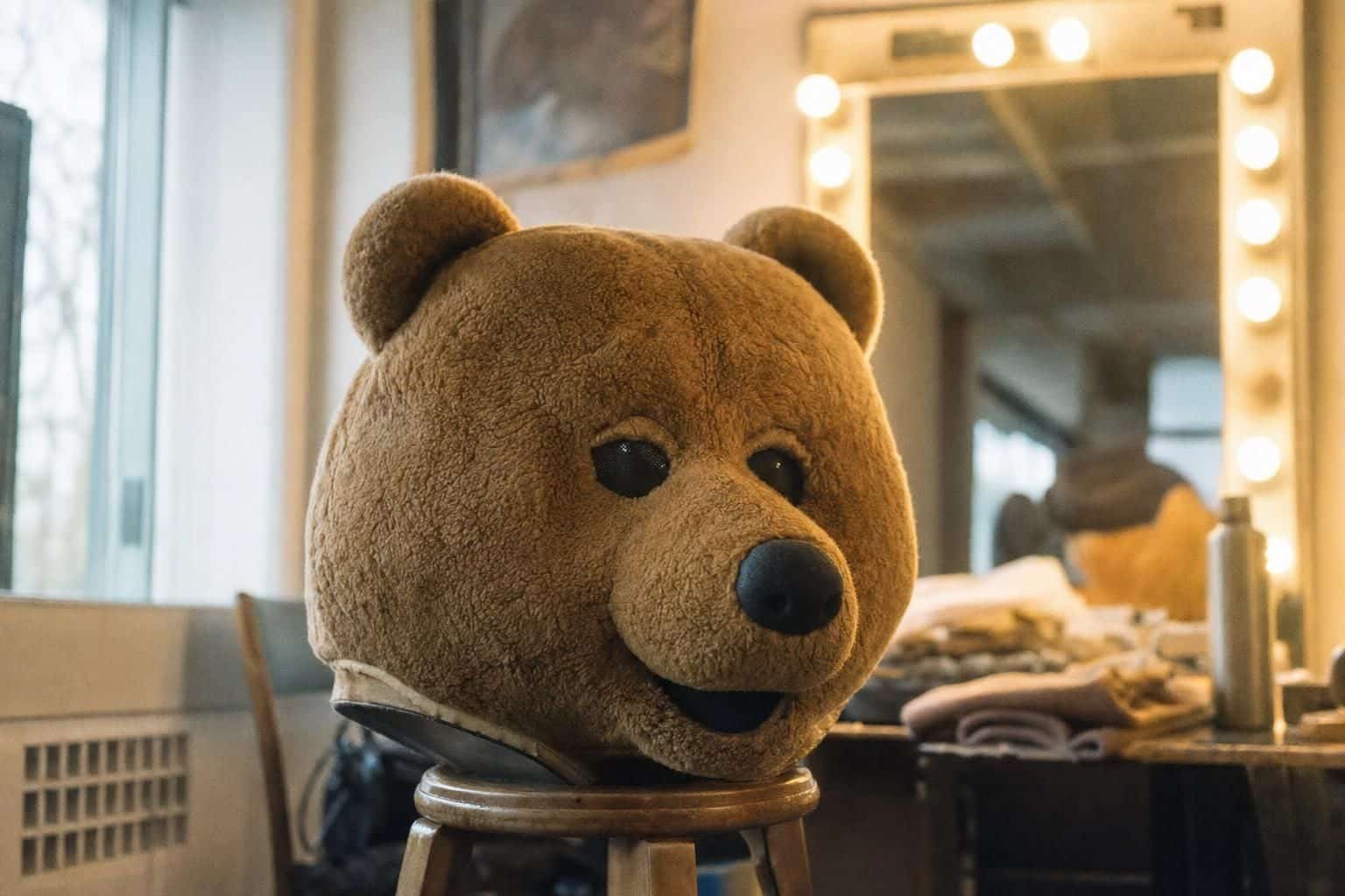 AI-generated image: a brown bear mascot costume head on a stool in a dressing room